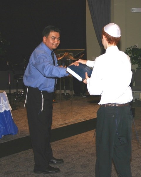 Presenting a an Artscroll Stone Chumash to Nathaniel Kegans at his Bar Mitzvah celebration (2009)